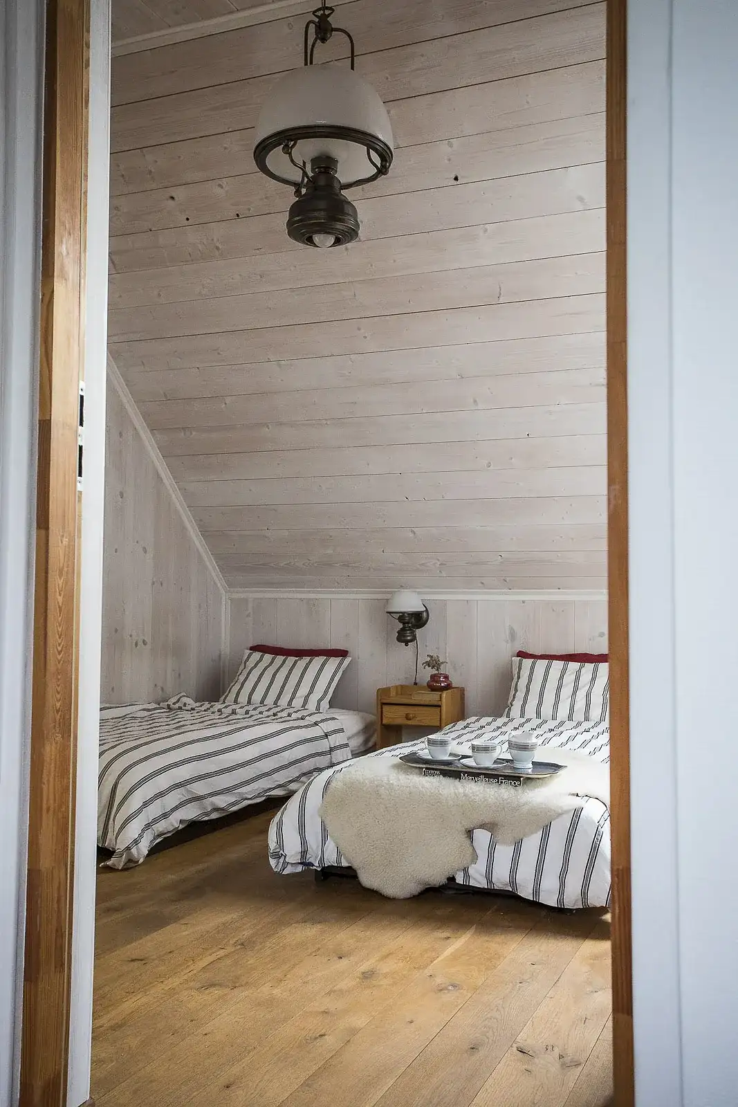 Sypialnia apartamentu z tacą z filiżankami i owczą skórą na łóżku